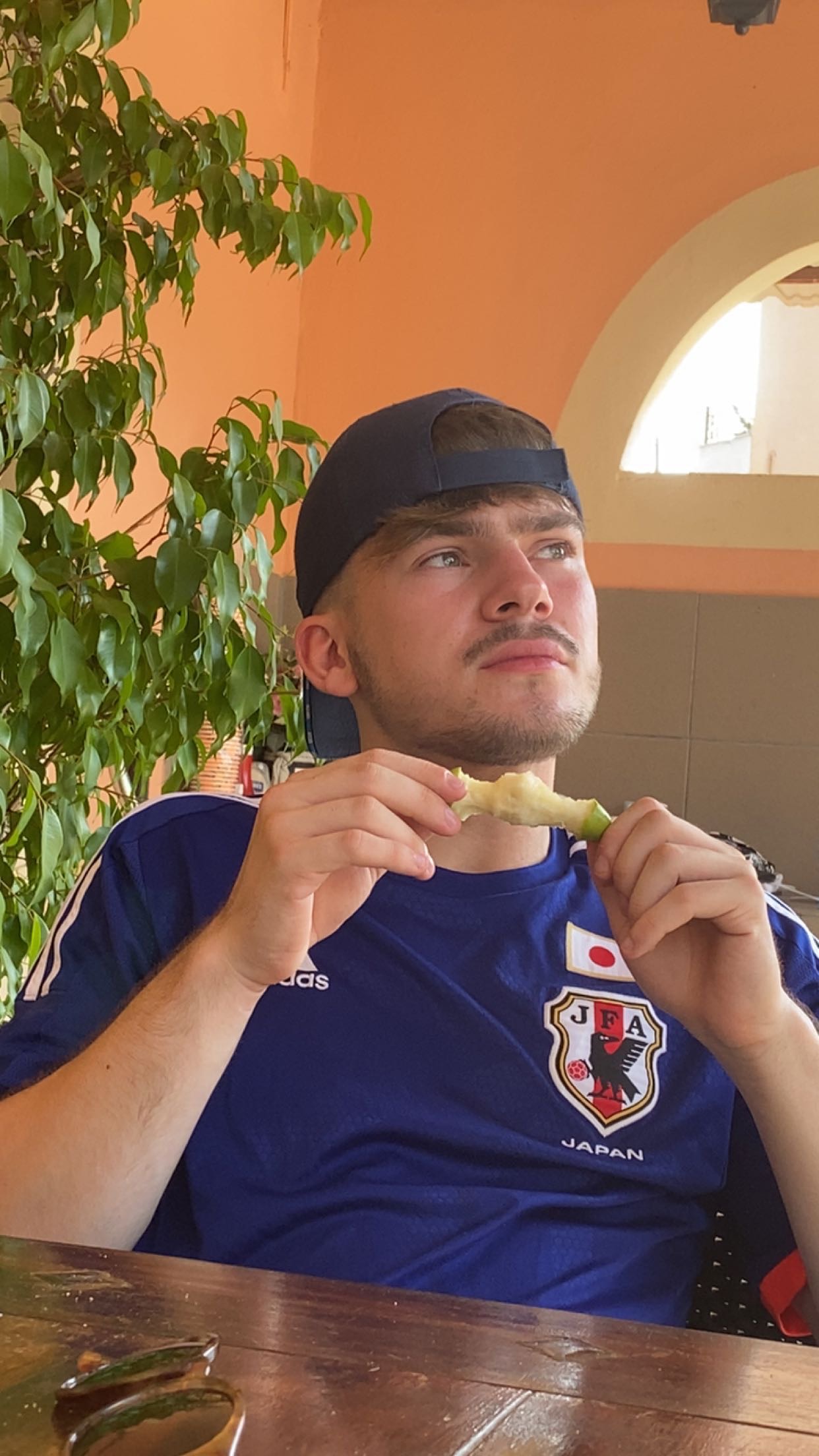 Me eating an apple in Greece wearing my Japanese football top.